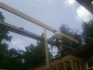 Carpenter setting a ridge beam over a new addition frame — Ice Dam Removal by Roofing Brothers in Armagh