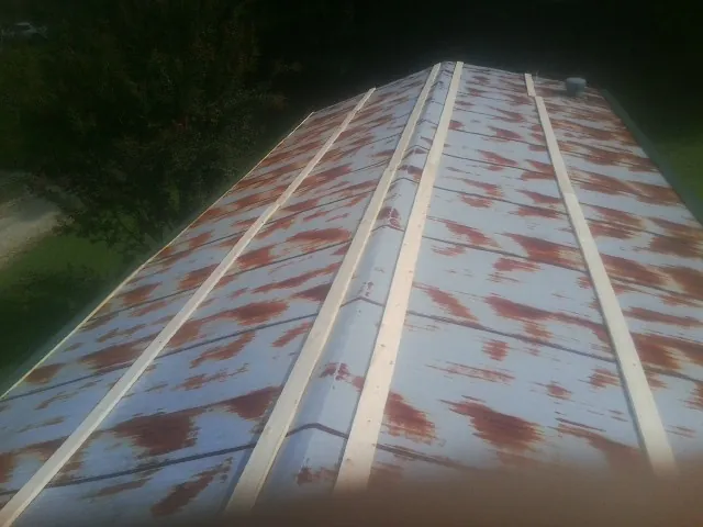 Rusted metal roof panels with new wood purlins before replacement — Storm Damage Roof Repair in Armagh by Roofing Brothers