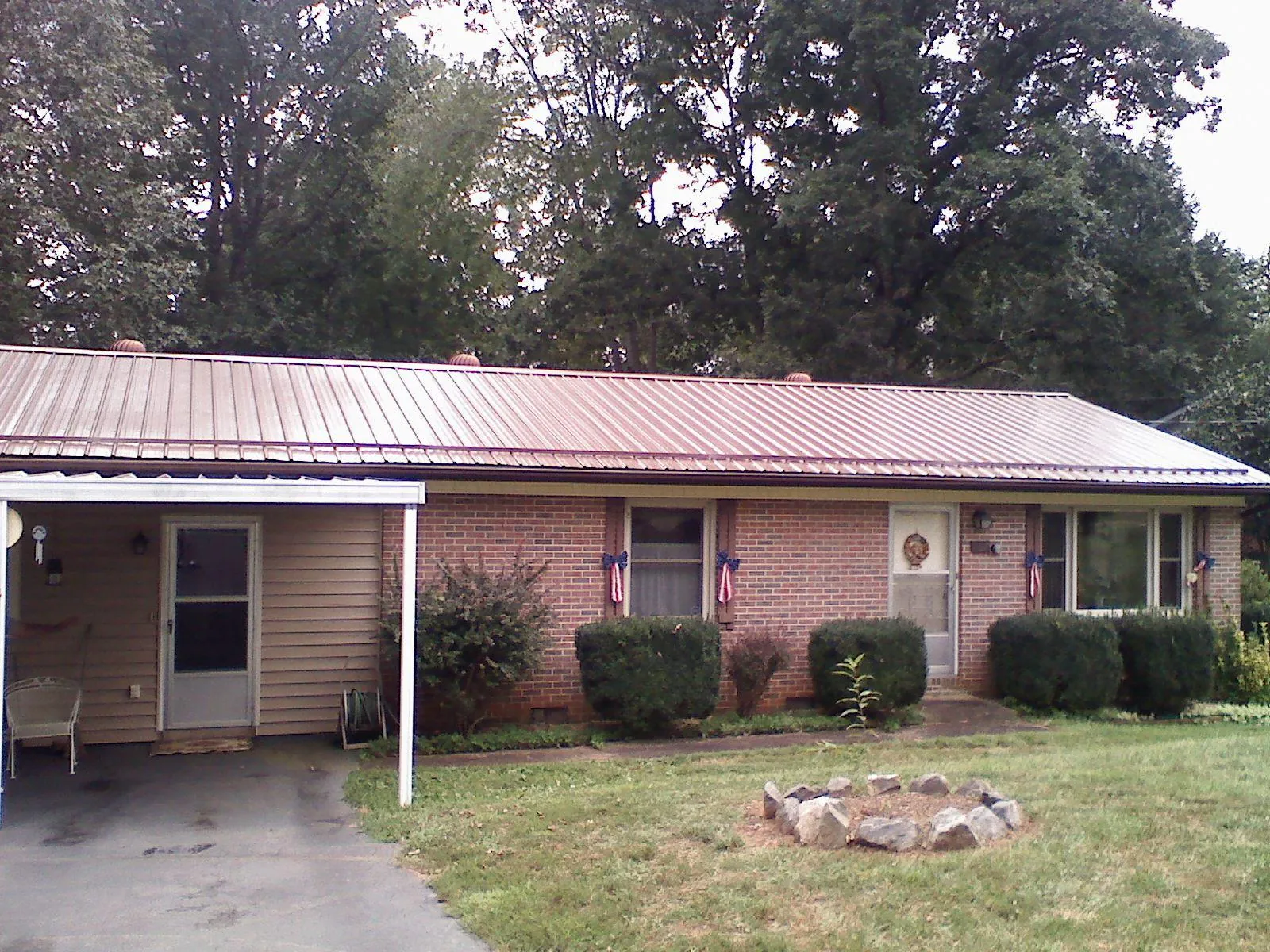 Bronze metal roof and carport on a brick ranch home — Roof Repair work by our crew in Armagh